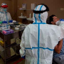 Una profesional sanitaria realiza una prueba PCR a un paciente. EFE/Enric Fontcuberta/Archivo