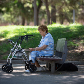 Una mujer lee bajo la sombra de unos árboles en el parque de la Barceloneta, a 13 de julio de 2022, en Barcelona. EUROPA PRESS