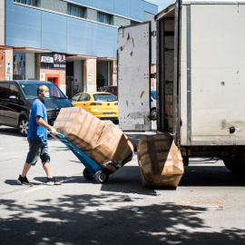 Un treballador del Polígon Sud de Badalona descarrega un camió per portar les mercaderies a una botiga. Miguel Velasco Alemndral.