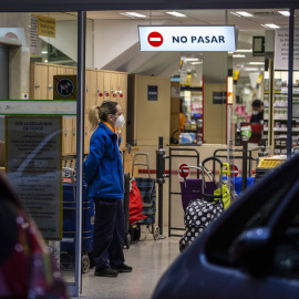 Una trabajadora de un supermercado vigila el aforo limitado durante el estado de alarma por la emergencia del coronavirus. / JAIRO VARGAS