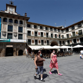 Varias personas pasean con su mascarilla puesta por la Plaza de los Fueros de Tudela donde se ha detectado un brote de coronavirus tras la celebración de una boda. EFE/ Jesus Diges