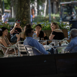 Varias personas disfrutan en la terraza de un bar de Barcelona.