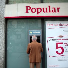 Un hombre utiliza un cajero de una oficina del Banco Popular en Madrid. REUTERS/Andrea Comas