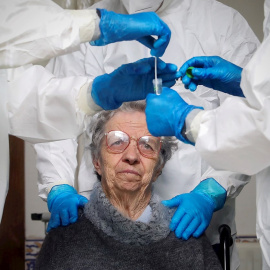 Un mujer observa al personal sanitario tras hacerse una prueba de coronavirus en la Fundación Comendador Joaquim De Sa Couto Foundation en Santa Maria da Feira, Portugal. EFE/ Jose Coelho
