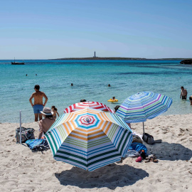 Varias personas disfrutan del buen tiempo durante el primer día de verano y primer día de la nueva normalidad en la playa de Punta Prima, Menorca. EFE/ David Arquimbau Sintes