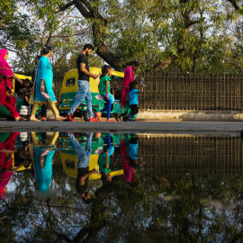 Varios habitantes de Nueva Delhi caminan por una calle encharcada. AFP/Chandan Khanna