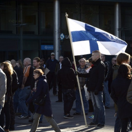 Un manifestante antiinmigración con una bandera de Finlandia durante una protesta en Helsinki. - AFP