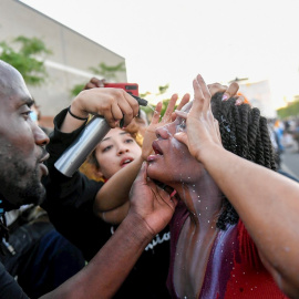 31/05/2020.- Un manifestante se limpia los ojos tras ser rociada con un spray por la policía durante las manifestaciones por quinto día consecutivo por la muerte de George Floyd en Minneapolis, Minnesota, Estados Unidos este domingo. EFE/ Craig Lassig