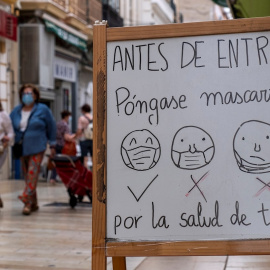 GRAFAND8946. HUELVA, 01/06/2020.- Un cartel colocado a la entrada de un establecimiento de Huelva informa a los clientes de la obligatoriedad y del correcto uso de las mascarillas durante la desescalada en el estado de alarma por la crisis sanitaria de la