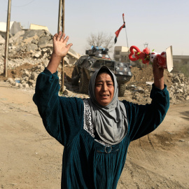 Una mujer levanta los brazos en medio de la batalla en Mosul (Irak). /REUTERS