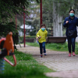 Un niño protegido con una mascarilla corre esta mañana por un parque de la ciudad de Valladolid durante el primer día en el que los menores de 14 años salen a la calle, acompañados de un adulto y durante una hora, después de más de cuarenta días d