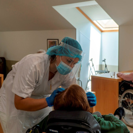 Una trabajadora atiende a una anciana en una residencia. EFE/ROMÁN G. AGUILERA/Archivo