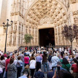 El arzobispo de Sevilla, Juan José Asenjo (c) muestra la Custodia de mano con el Cuerpo de Cristo en una de las puertas de la Catedral de Sevilla al suspenderse la procesión por las calles debido al estado de alarma por la crisis sanitaria de la covid-1