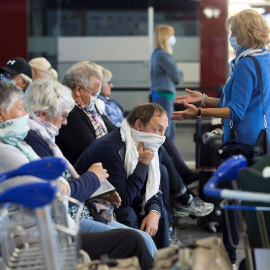 Varios pasajeros con mascarilla esperan su vuelo en las instalaciones del Aeropuerto de Málaga durante la octava jornada de confinamiento tras decretarse el Estado de Alarma por el coronavirus (Covid-19). EFE/Daniel Pérez