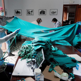 La concejala de Sanidad de Benetússer (Valencia), Aroa Juan (i), trabaja junto a otras voluntarias en las dependencias del ayuntamiento confeccionando mascarillas con material facilitado por el Hospital Peset de València, su centro de referencia, en una