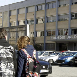 Dos jóvenes pasan por la puerta del colegio Valdeluz. /EFE