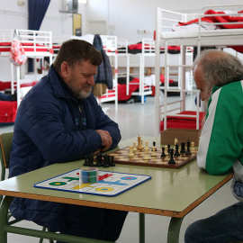 Dos usuaris del centre temporal per a persones sense llar jugant a escacs el 24 de març de 2020. Norma Vidal/ ACN.