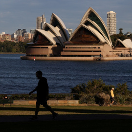 Varias personas paseando por el parque frente a la Ópera de Sydney (Australia), en medio de las restricciones por la pandemia del  coronavirus. REUTERS / Loren Elliott