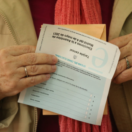 Una anciana con las papeletas preparadas para ejercer su derecho a voto en el Colegio Joaquín Turina, a 4 de mayo de 2021, en Madrid (España). Foto: Isabel Infantes / Europa Press
