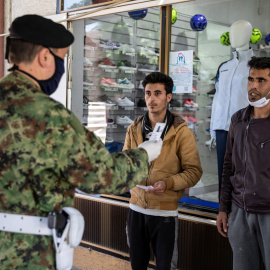 Soldados serbios registran a varios migrantes junto al campo de Sid. - REUTERS