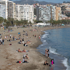 Varias personas toman el sol en la playa de La Malagueta. EFE
