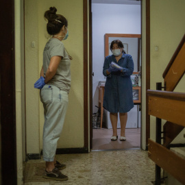 Una voluntària de l'ONG Proactiva Open Arms lliura a una dona material sanitari en plena crisi de la Covid-19. David Zorrakino / Europa Press