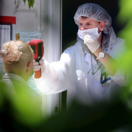 Una trabajadora sanitaria toma la temperatura a una persona. EFE/Archivo