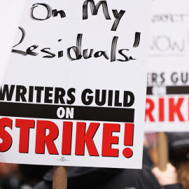 Los miembros del Writers Guild of America (WGA) East sostienen carteles mientras caminan en la línea de piquete fuera del Peacock NewFront el 2 de mayo de 2023 en la ciudad de Nueva York.- AFP