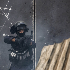  12 de octubre de 2022, Israel, Jerusalén: Un soldado israelí apunta su arma durante los enfrentamientos con jóvenes palestinos en el campo de refugiados de Shuafat.- DPA