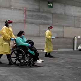 Una de las primeras pacientes llegando al recinto de Ifema habilitado como hospital por módulos | EFE