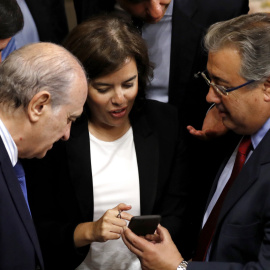 La vicepresidenta del Gobierno, Sorya Sáenz de Santamaría, conversa con el ministro del Interior, Juan Ignacio Zoido (d), y los diputados del PP Jorge Fernández Díaz (i) y José Luis Ayllón (2-i), durante un receso en el debate de las enmiendas a la 