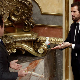 El líder del PP, Pablo Casado (d), y el secretario general del PP, Teodoro García Egea, desinfectan sus manos durante un pleno en el Congreso. - EFE