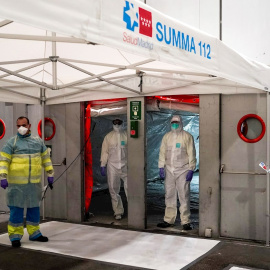 Personal sanitario accede por una zona protegida mientras comienzan a llegar los pacientes con coronavirus. EFE