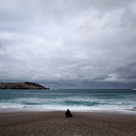 16.02.2020. Una mujer frente a la playa de Riazor de A Coruña, donde este domingo se mantiene el fuerte oleaje. EFE/Cabalar