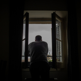 Una persona treu el cap a la seva finestra durant el primer dia laborable de la segona setmana des que es va decretar l'estat d'alarma a l'estat a conseqüència del coronavirus, a Barcelona. David Zorrakino / Europa Press