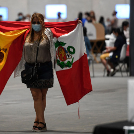  Una residente peruana camina con banderas españolas y peruanas después de emitir su voto para la segunda vuelta de las elecciones presidenciales en un colegio electoral en el centro de congresos de Ifema en Madrid el 6 de junio de 2021.- AFP