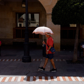 Un hombre se protege del fuerte sol con una paraguas, en Ronda (Málaga)- REUTERS/Jon Nazca