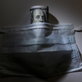 24/03/2020 - Un billete de dólar y una mascarilla. / REUTERS - Alexey Pavlishak