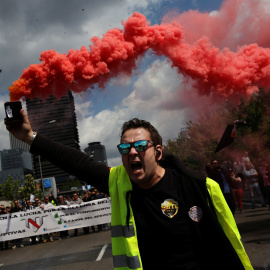 Un conductor de taxi sostiene una bengala durante la protesta contra las empresas de economía colaborativa como Uber, a las que acusan de 'dumping', este miércoles en Madrid. REUTERS/Susana Vera