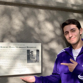 Milton Zerman posa junto a la placa conmemorativa de Robert Merriman colocada en la fachada del antiguo hogar de los Merriman en Berkeley.