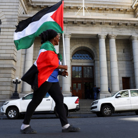 Una mujer marcha con una bandera palestina en una manifestación en apoyo del pueblo palestino tras los últimos ataques de Israel, en Ciudad del Cabo (Sudáfrica). REUTERS/Esa Alexander