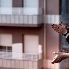 Dos personas aplauden a los sanitarios en un bloque de viviendas de Orense./ Brais Lorenzo (EFE)