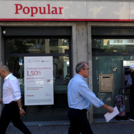Varios transeuntes pasan junto a una oficina del Banco Popular en Madrid. REUTERS/Juan Medin
