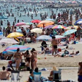 Un gran número de personas se ha acercado a la playa de la Patacona para disfrutar del buen tiempo veraniego y mitigar las altas temperaturas que se viven este fin de semana. EFE/Kai Försterling
