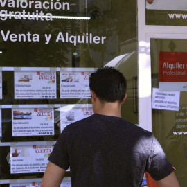 Un hombre mirando un escaparate de pisos. EFE