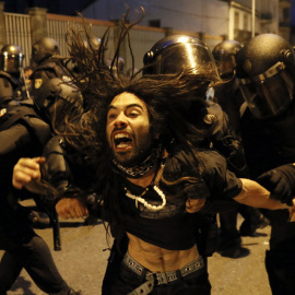 La policía desaloja a un manifestante del interior de un inmueble tras la manifestación por calles de Santiago de Compostela.- EFE