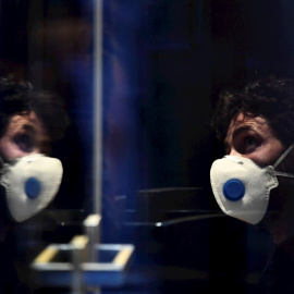 un hombre con mascarilla en un hotel en Innsbruck, Austria, donde una mujer ha dado positivo en coronavirus. - EFE