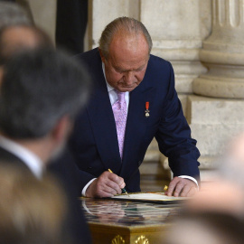 Juan Carlos I firma su abdicación, en una ceremonia en la Sala de Columnas del Palacio Real de Madrid, el 18 de junio de 2014. AFP/GERARD JULIEN
