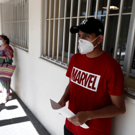 Dos personas esperan su turno para realizarse una prueba de PCR dentro del Plan COVID-19 de la Comunidad de Madrid, que se ha iniciado hoy con un dispositivo instalado en el distrito madrileño de Carabanchel para la realización de esta prueba en poblaci