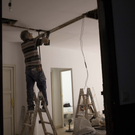 Un albañil trabaja en la reforma de un piso en la calle Santa Ana que pasará a alojar turistas.- JAIRO VARGAS
